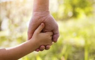 child holds older person's hand