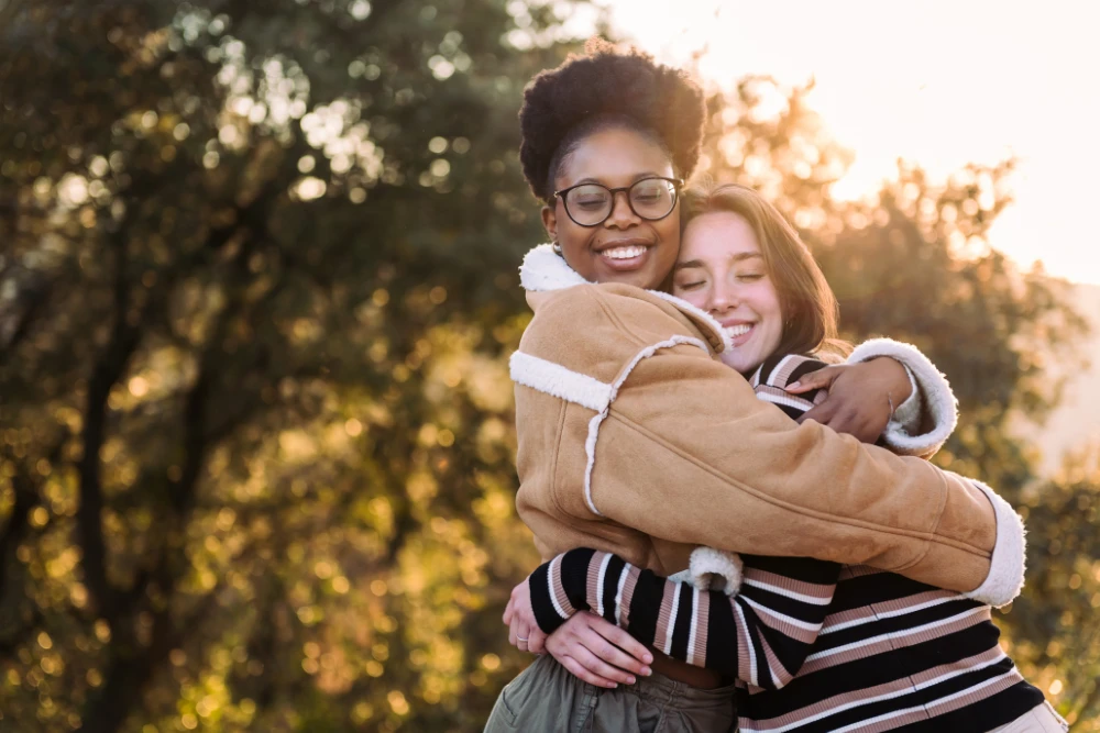 two lovely friends hugging in nature at sunset 2023 11 27 05 15 05 utc