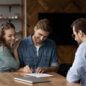 happy millennial couple signing property purchase contract