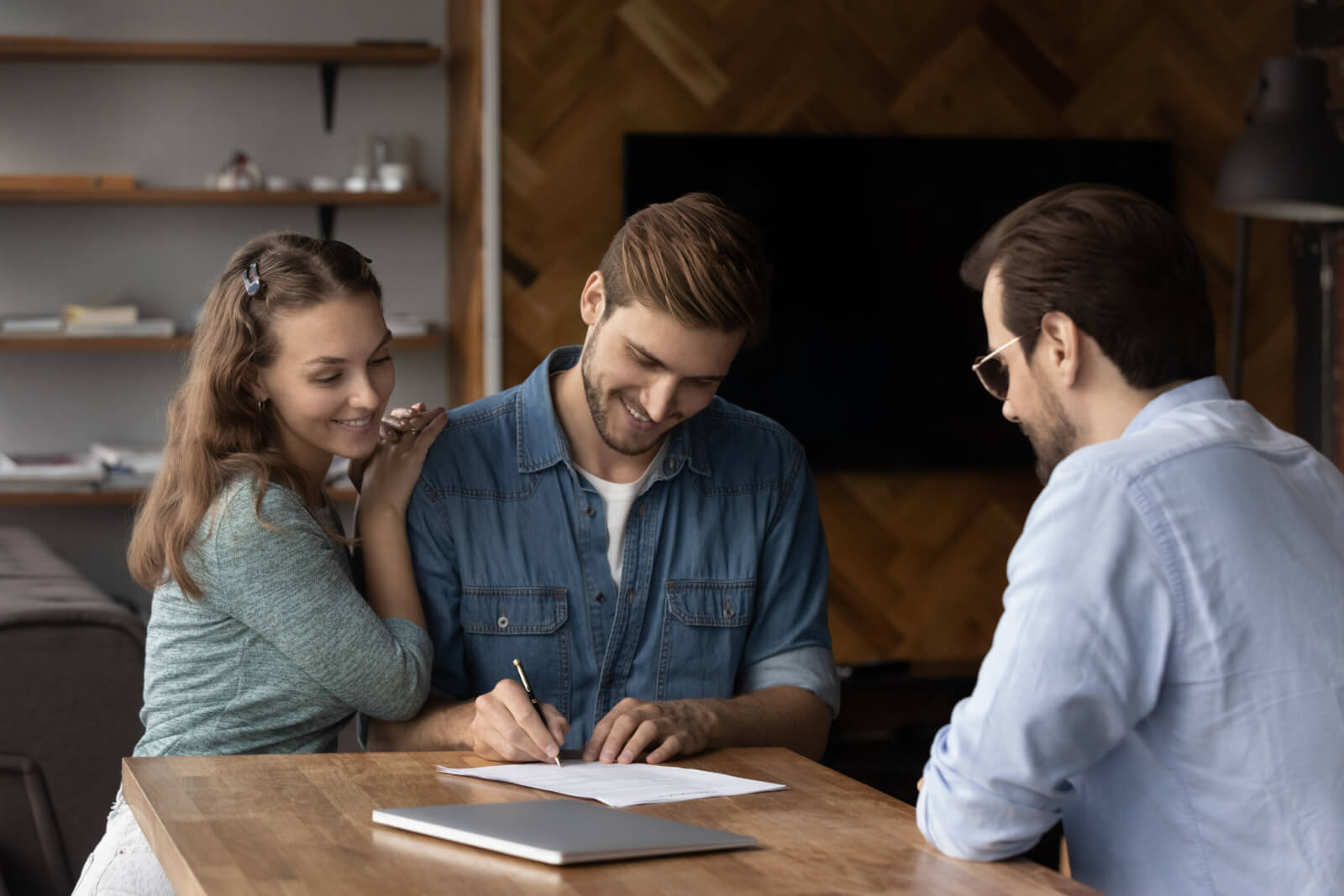 happy millennial couple signing property purchase contract